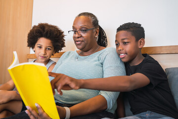 Grandmother reading a book to grandchildren.