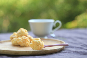 Choux cream, small fluffy creamy yummy vanilla inserted in round dessert as cold fresh sweet on wood plate.