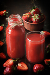 Fresh strawberry smoothies on a dark surface. Healthy summer detox.