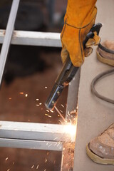 Engieer safety for welding and hard ware working in plant for line production lines.  Yellow Steel welding safety gloves on long iron bars on floor for building in constraction.