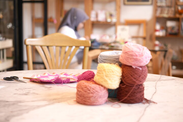 Crochet thread in group as many colors in studio of handicraft school as background. Needles craft on table for hand made hobby.Crochet yarn bag with cotton yarn.