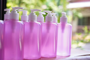 Alcohol gel in pump with pink gel and good smell of high prevention for hand protection from Corona virus. Covid-19 hand sanitizer. Shampoo bottle with white press pump.