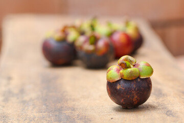 Fresh red and purple mangosteen on wood table. Queen of fruit, good for Anti-anging. Asian local Thai fruit with white fruit after peeling hard shell.