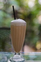 Cocao with milk or chocolate latte  with vanillawhipping in cafe. Fresh and dessert in tall glass. Outdoor space