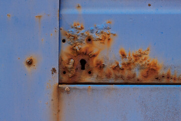 Very old rusty metal door close up. Blue retro detail background.
