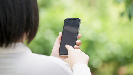 女性・新緑・スマホ