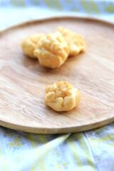 Choux cream, small fluffy creamy yummy vanilla inserted in round dessert as cold fresh sweet on wood plate.