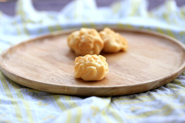 Choux cream, small fluffy creamy yummy vanilla inserted in round dessert as cold fresh sweet on wood plate.