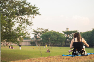 Obraz premium Young girl seated and reading a book in a park