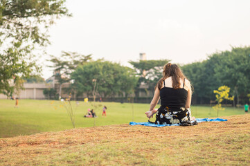 Young girl seated and reading a book in a park