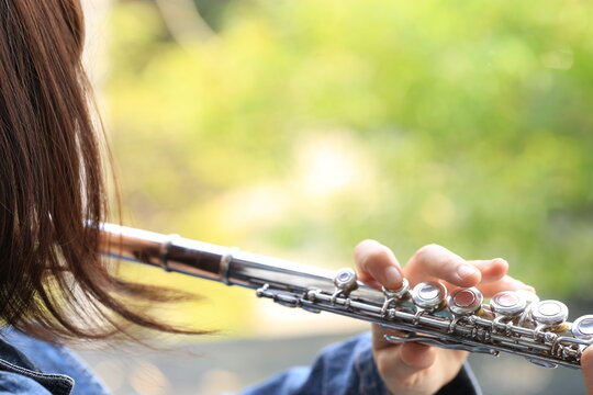 Flute Classical Instrument Player Playing Song. Instructor Practicing Bronze Woodwind For Orchestra As Solo With Green Bokeh Outside With Nature.