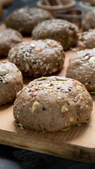 Brown whole wheat bread with multi grain in preparing to get dough for baknig as healthy bread on black background with wood board and roll. Sesame and seeds on bread.