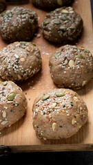 Brown whole wheat bread with multi grain in preparing to get dough for baknig as healthy bread on black background with wood board and roll. Sesame and seeds on bread.