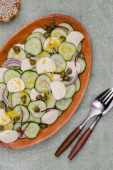 Salad of cucumbers, cheese, capers and lemon zest