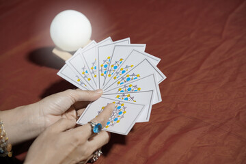 Tarot card reading on cloth for fate or fortune telling through design card. Gypsy paranormal in...