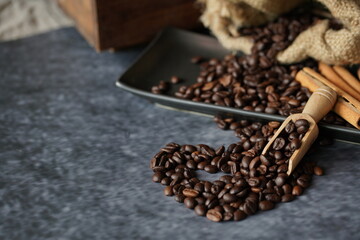 Dark roasted coffee bean with wooden spoon and assorted sugar and cream with bakery preparation for cafe or coffee shop.