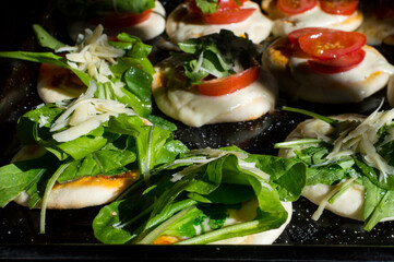 Pizzas with cheese, fresh arugula, parmesan and cherry tomatoes