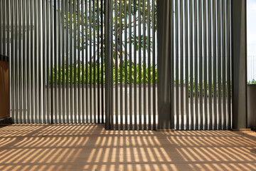 modern architectural shaded garden indoor outdoor area with vertical slats casting strong shadows...