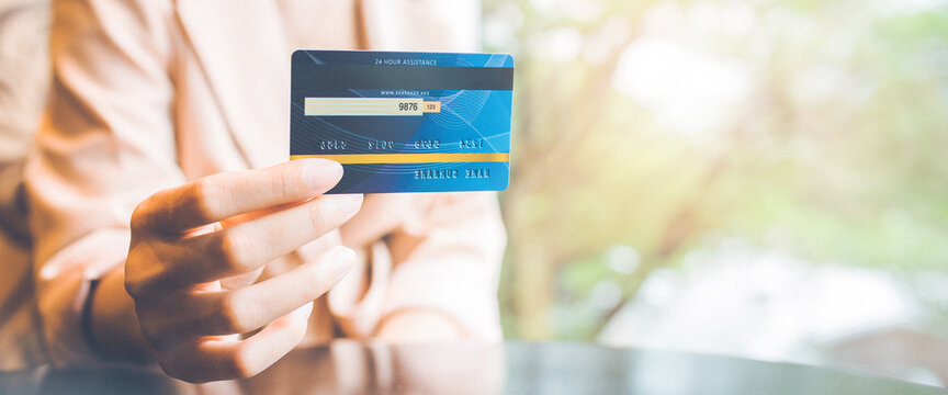 Business woman hand holds a blue credit card to make a purchase.For web banner.