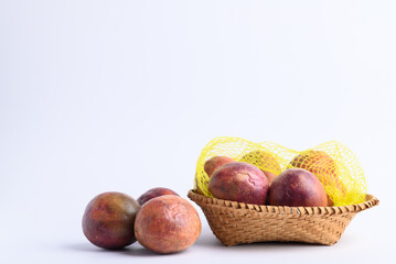 Obraz premium Fresh passion fruit in a basket on white background, Tropical fruit in summer season