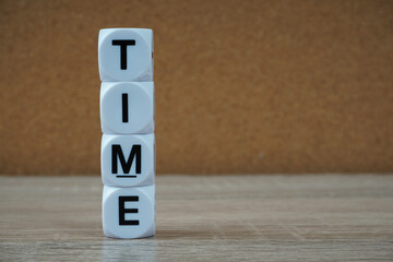 word TIME on a cubes over wooden banckground