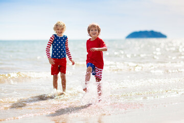 Kids with American flag on beach. 4th of July.