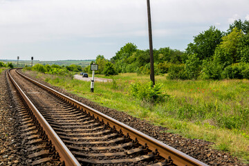 Summer landscape with railroad rails and road