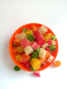 Top view of raw fryums in an orange bowl in isolated white background