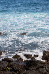 Rock and sea. View of turuoise water and lava rocks beach, atlantic ocean waves. Topical travelling background. Tenerife or Hawaii islands.