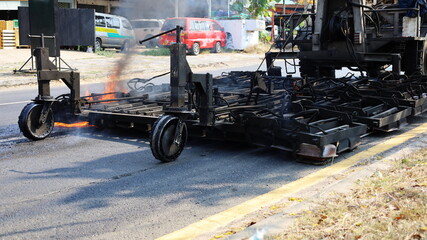 Close up Panel heating machine on street. Heating system of an outdoor preheating unit with propane gas burns a asphalt surface on a highway background with copy space.