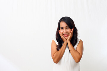 Beautiful young Asian girl smiling sweetly at the camera, putting her palm on her chin. Isolated on white background