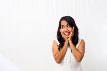 Fototapeta premium Beautiful young Asian girl smiling sweetly while looking beside her, putting her palm on her chin. Isolated on white background