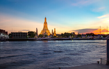 Fototapeta na wymiar View of beautiful Wat Arun Rajvararam or Wat Arun or Wat Makok at waterfront of the Chao Phraya River in twilight,Which is historical significance and famous tourist destination of Bangkok,Thailand.