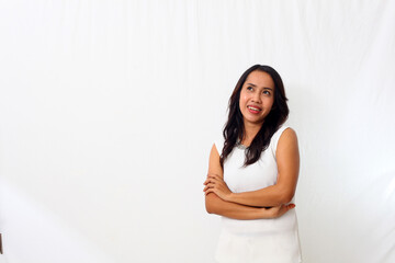 The beautiful young Asian girl smiled as she folded her arms and looking at blank space. Isolated on white background