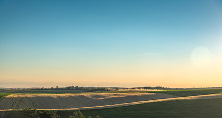 Summer sunset among fields