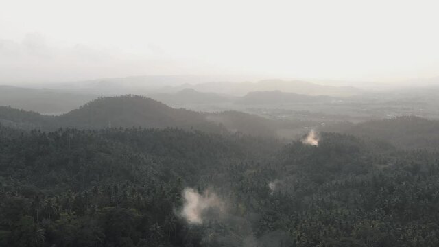 Apocalyptic scenery of misty morning over the hills with steam coming out from the forest. Camalig Albay, Philippines