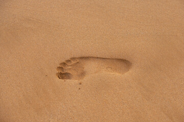 Fototapeta na wymiar Footprints in the sand. Human foot prints on beach sand.