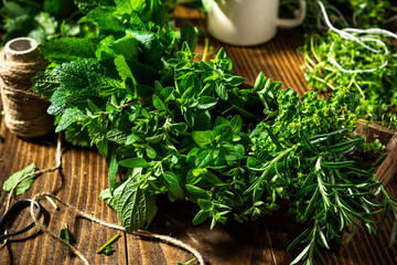Bunch of Aromatic Fresh Herbs on Wooden Kitchen Table.
