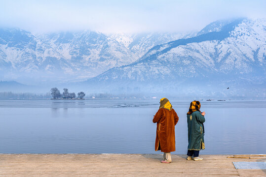 Two local Kashmiri women enjoying in front of Char Chinar at Dal Lake Srinagar, Kashmir, India.