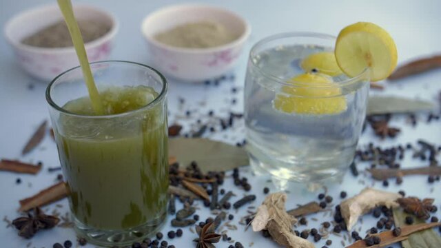 Refreshing Jaljeera drink with fresh mint leaves and Boondi pouring in a clear glass. Famous Indian spices like cinnamon  cloves  black pepper  and bay leave together with a soda carbonated water