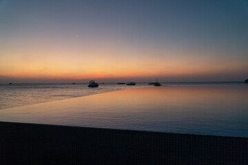 Wide panoramic landscape of stunning sunset over Indian Ocean on Maldives island. Exotic tropical island beach background. 