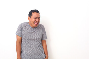 Portrait of Asian man with funny facial expression. Sticking his tongue out