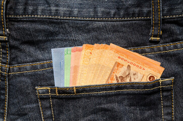 Malaysian banknotes in the back pocket of blue jeans
