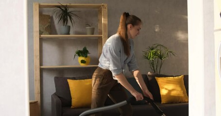 Girl vacuums and holds vacuum cleaner like guitar and dances with it. Young woman having fun while cleaning house with vacuum cleaner dancing like guitarist