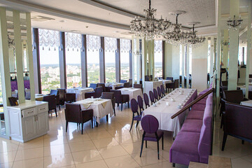 Interior of cozy luxury restaurant with view of the modern city