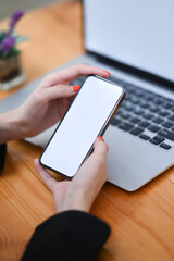 Close up view businesswoman holding mock up mobile phone with blank screen.