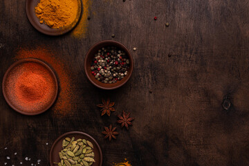 Different spices on a wooden background