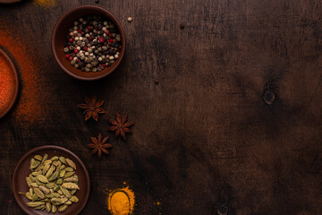 Different spices on a wooden background