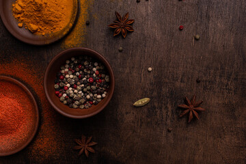 Paprika, pepper, cardamon, salt and turmeric on a wooden background, flat lay