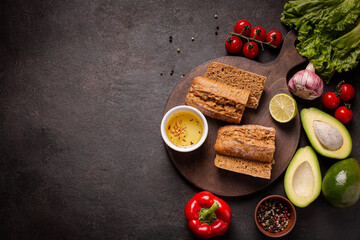Fresh vegetables and bread on a wooden board, top view, background, copy space